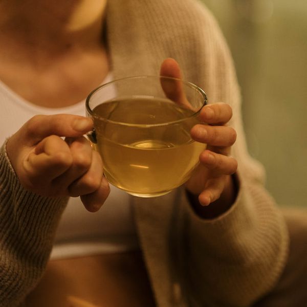 Person calmly sipping tea by a window, integrating mindfulness into their day.